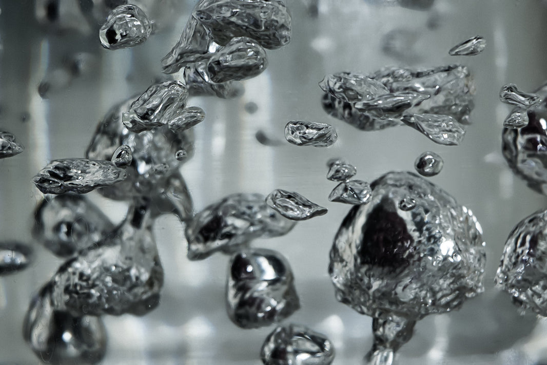 Primo piano di bolle d'acqua che illustrano il processo di filtrazione dell'acqua e l'importanza della qualità dell'acqua potabile.