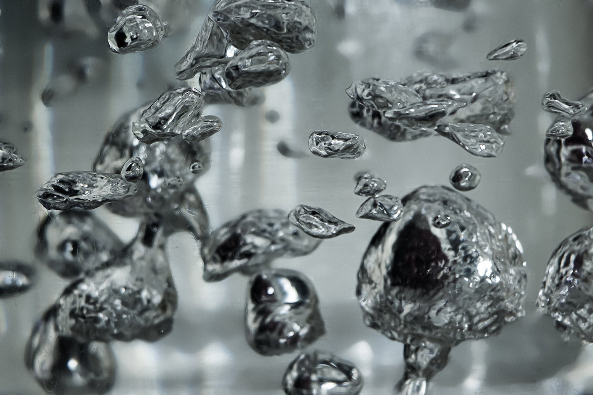 Primo piano di bolle d'acqua che illustrano il processo di filtrazione dell'acqua e l'importanza della qualità dell'acqua potabile.